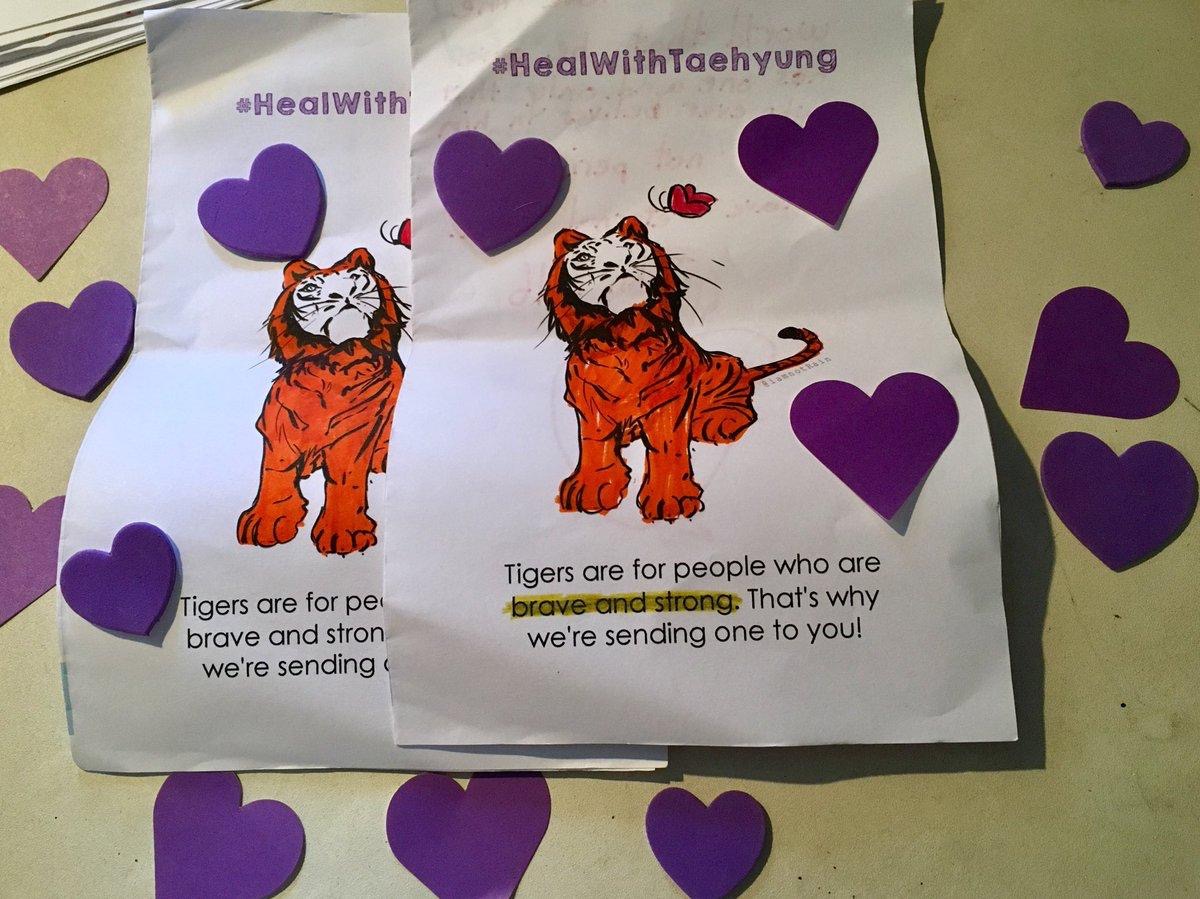 Photo showing printed out colouring pages with tigers on them. Purple hearts cut out of construction paper are scattered across the colouring pages.