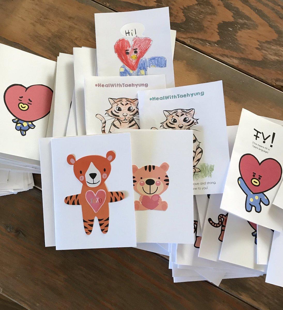 Photo of printed cards. Some cards feature cartoon tigers and some are pictures of BT21 character Tata.