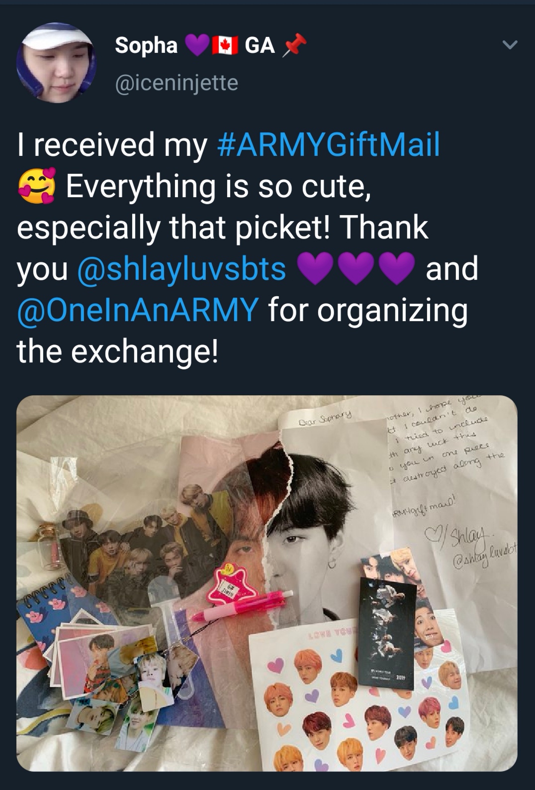 Tweet that shows what an ARMY received from the ARMY Gift Swap. Photo shows pictures of BTS from their Map of the Soul : Persona album, stickers of BTS' faces, a handheld fan, a keychain with small pictures of Jimin attached, and a large photo of Yoongi