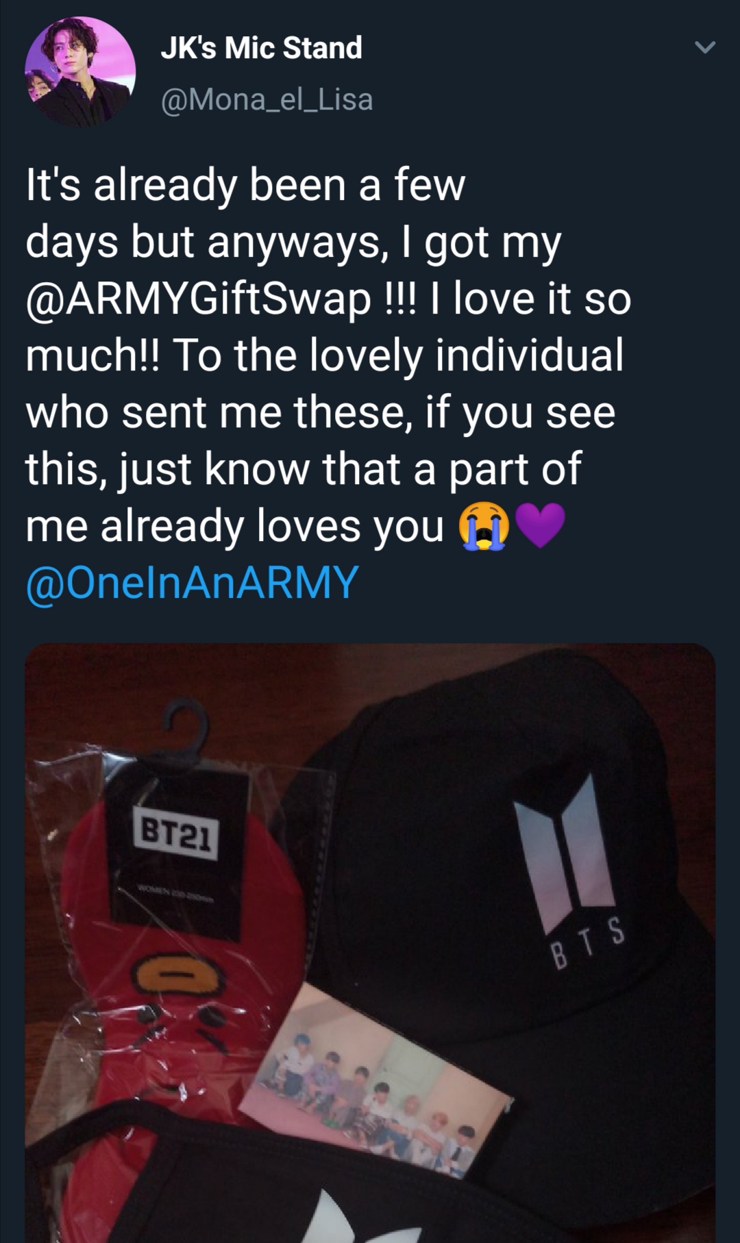 Tweet that shows what an ARMY received from the ARMY Gift Swap. Photo shows a black ballcap with the word BTS and BTS' logo on it, a pair of socks with BT21 Tata's face on them, and a photocard from BTS' album Map of the Soul : Persona